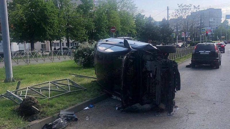 Иномарка врезалась в забор и опрокинулась на бок после ДТП в Краснодаре