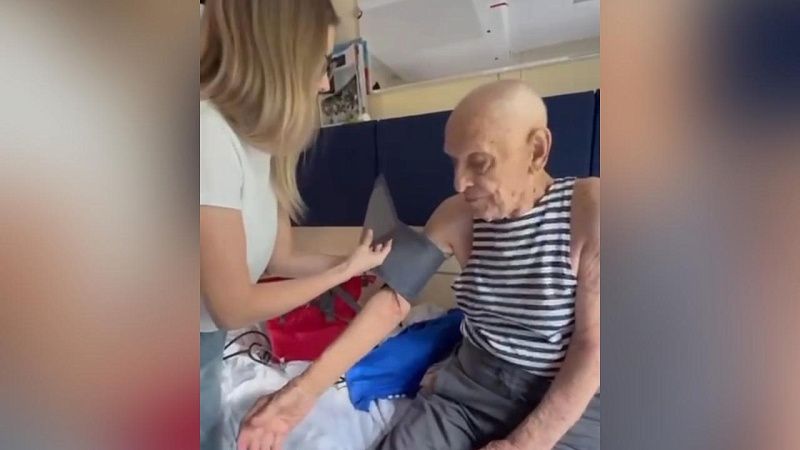 Врач сопровождает 104-летнего ветерана из Геленджика, поехавшего на Парад Победы